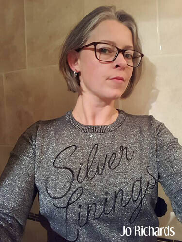 Jo with short gray hair in silver linings sweater