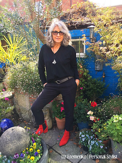 Image of Liz in all black with red boots in her garden