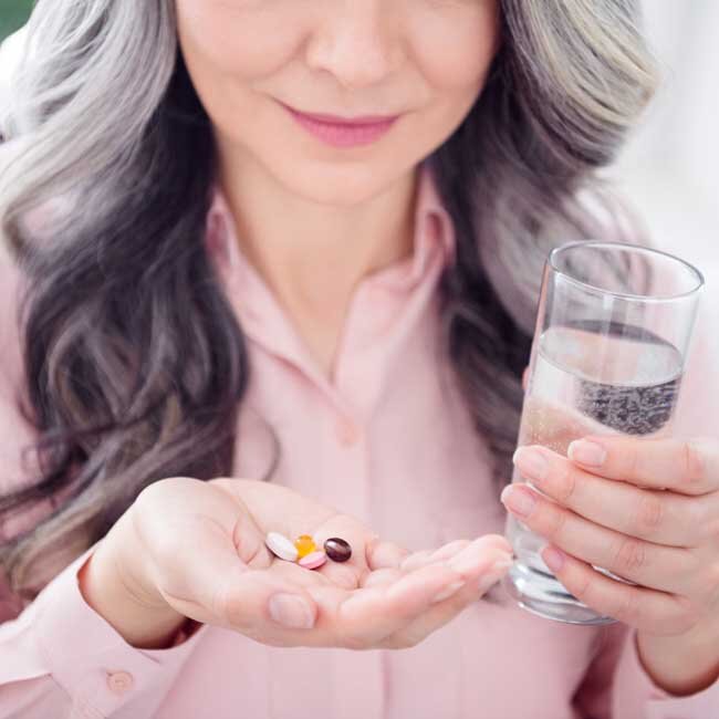 Woman with Gray Hair Taking her vitamins
