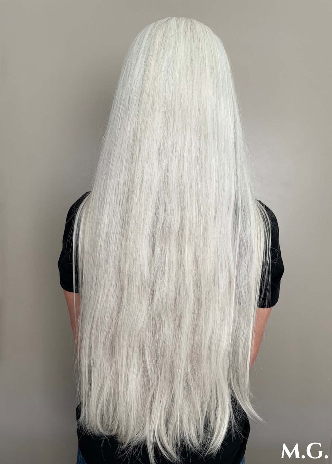 Woman facing away with hip length long white hair