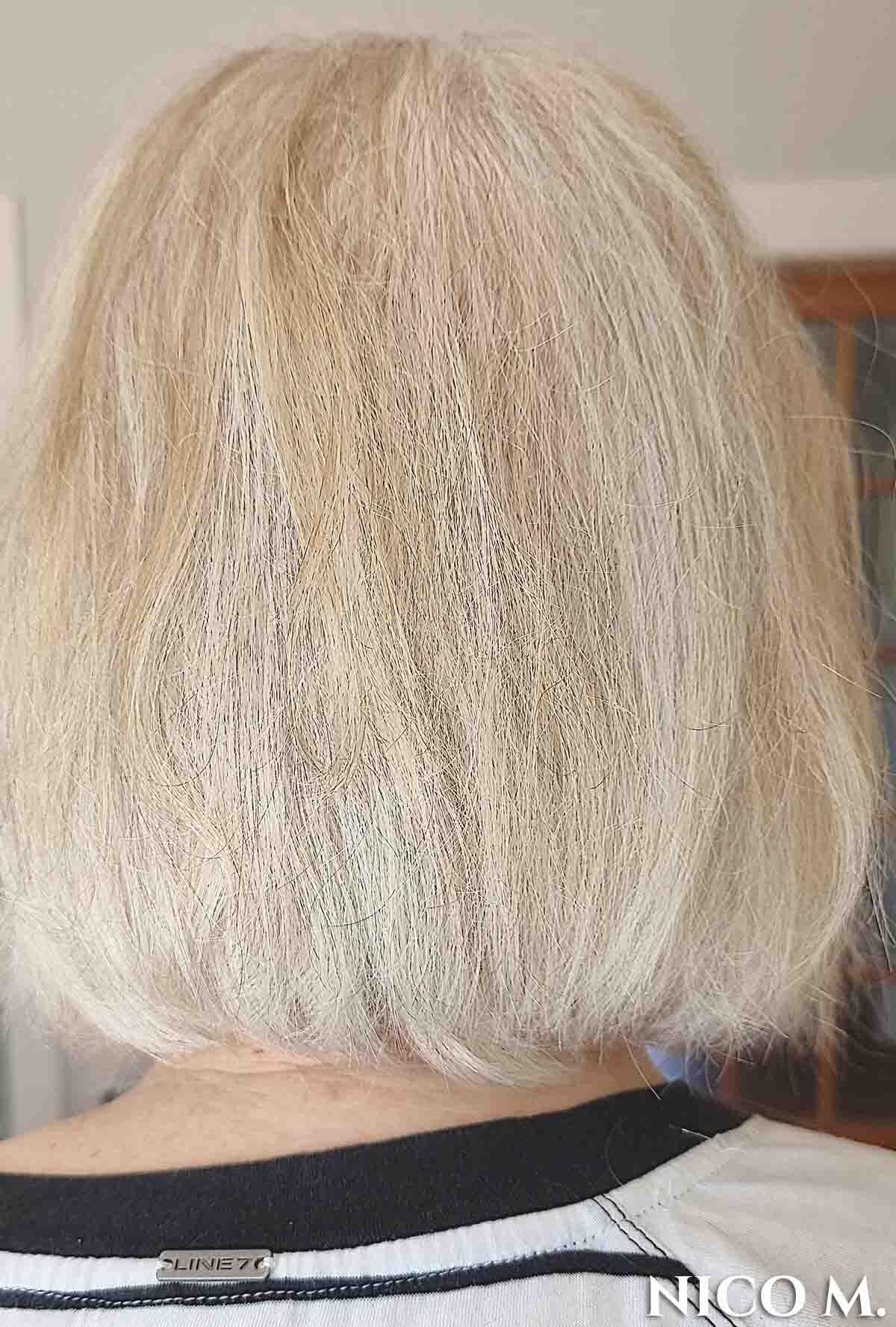 Woman facing away with shoulder length bob with white hair.