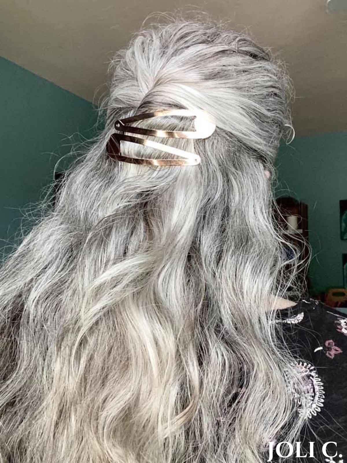 Joli Campbell facing away with long silver hair in soft loose waves.
