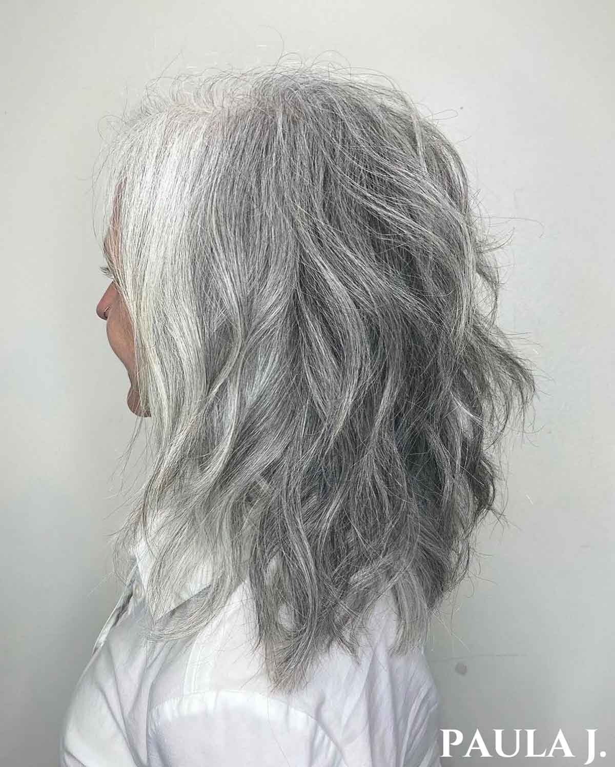 Woman facing left with short wavy silver hair.