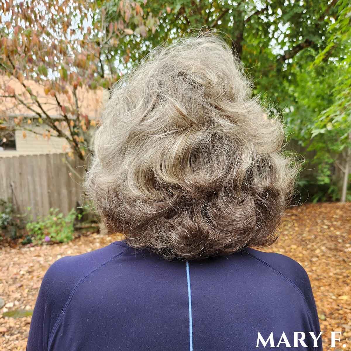 Woman facing away with short wavy silver hair.
