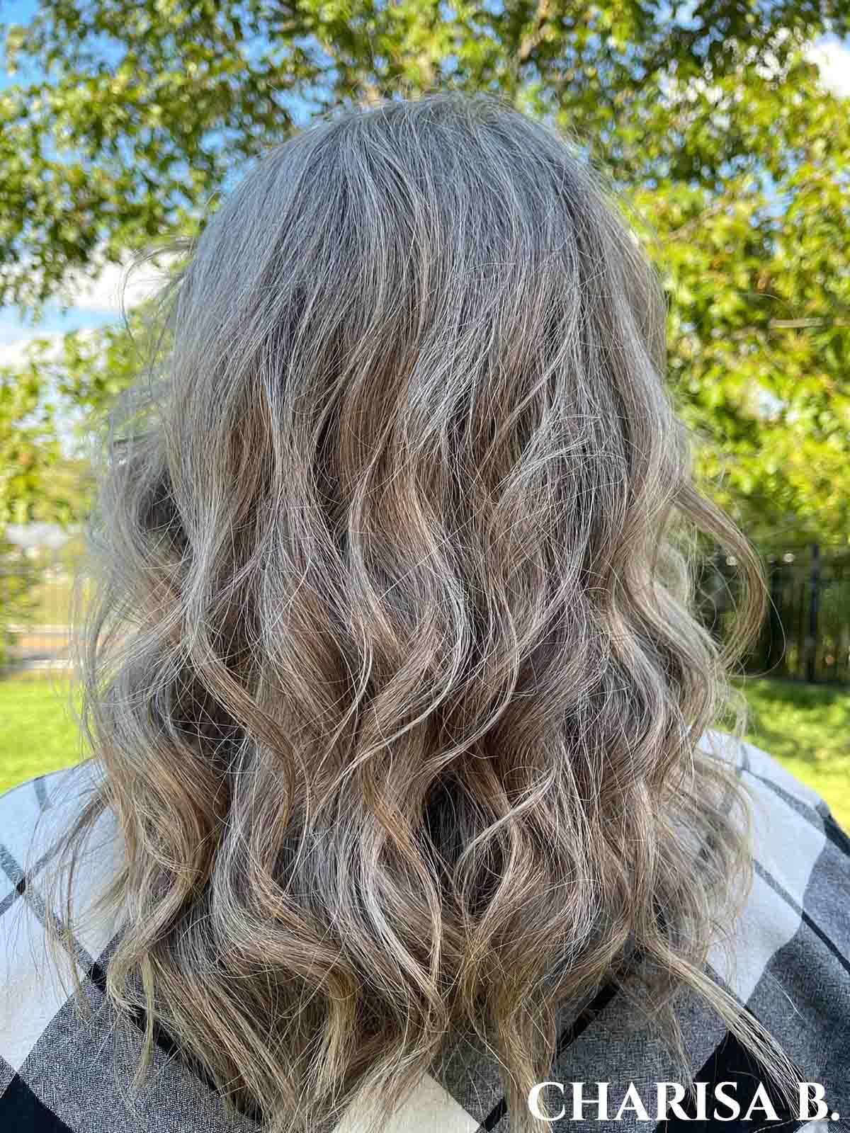 Woman facing away with long wavy silver hair.